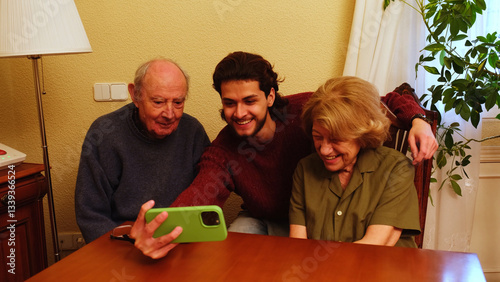 Obraz na płótnie Elderly couple and their grandson using a smartphone for video call at home w salonie