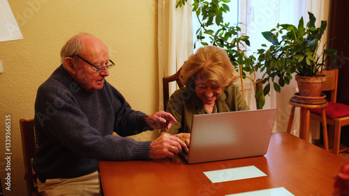 Obraz na płótnie Senior couple browsing internet on laptop, happy and smiling, enjoying technology in their home w salonie