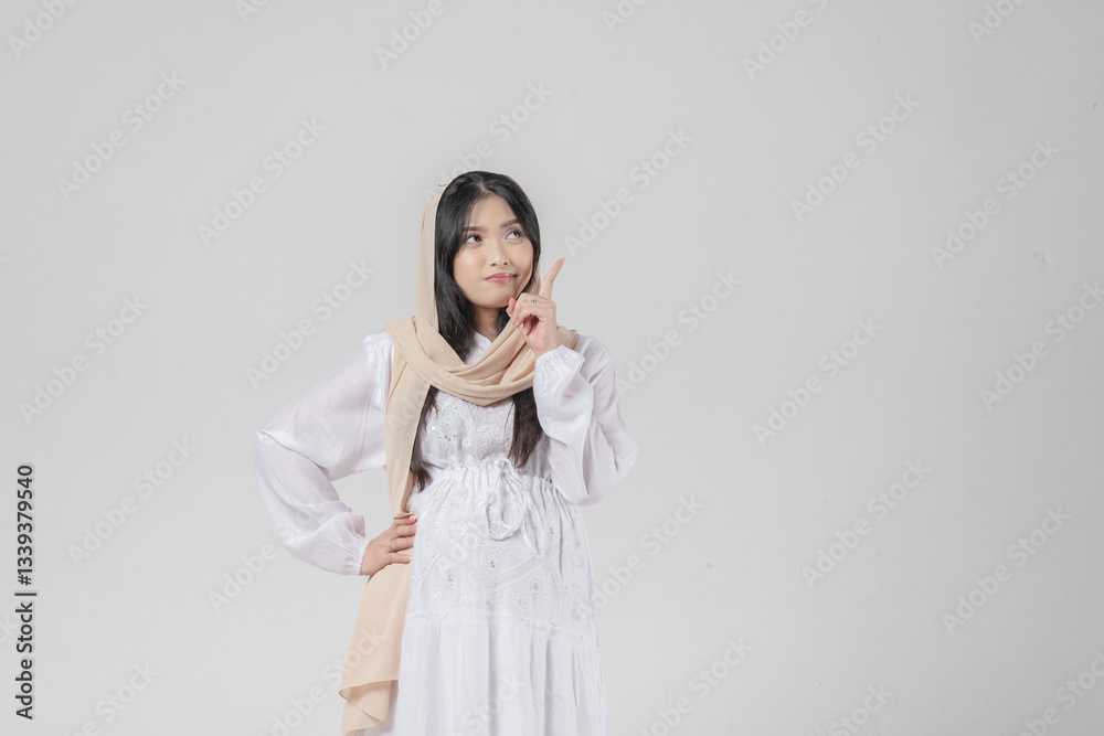 Surprised Asian Muslim pregnant woman in hijab pointing to the copy space upwards. Surprised Asian Muslim pregnant woman in hijab pointing to the copy space upwards.