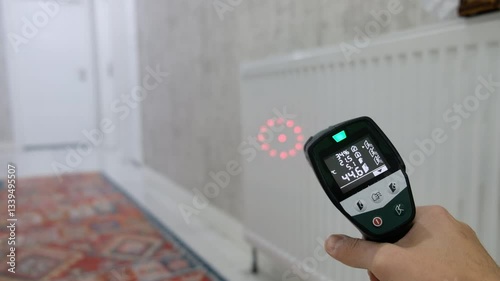 Measuring Radiator Temperature with Infrared Thermometer in Marble Floor Hallway