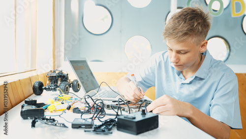 Принти на полотні Caucasian boy fixing main board while study construction by using laptop analysis data