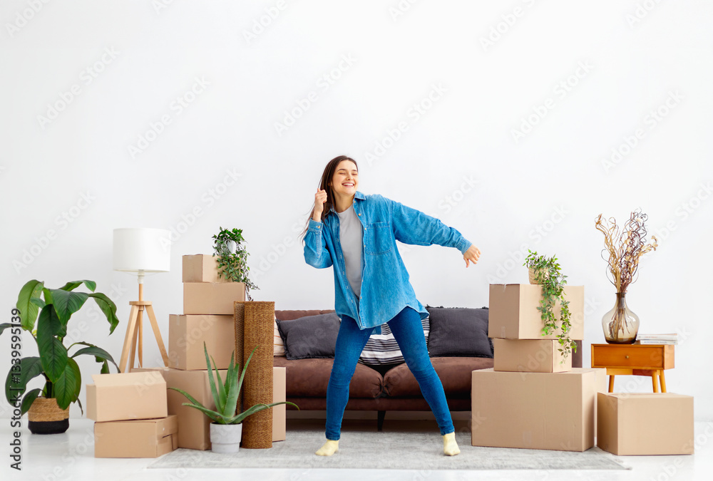 Excited young woman dancing during home move