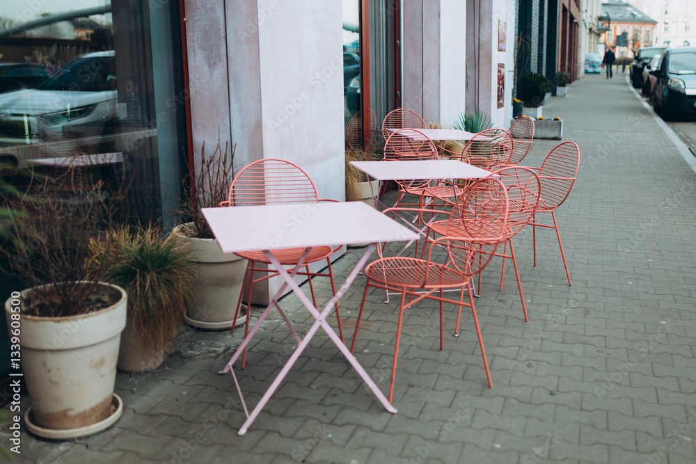Modern outdoor terrace with seating arrangement. Fashionable outdoor restaurant tables, summer time. Tables and chairs at sidewalk cafe. Touristic setting, cafe table, sidewalk cafe furniture