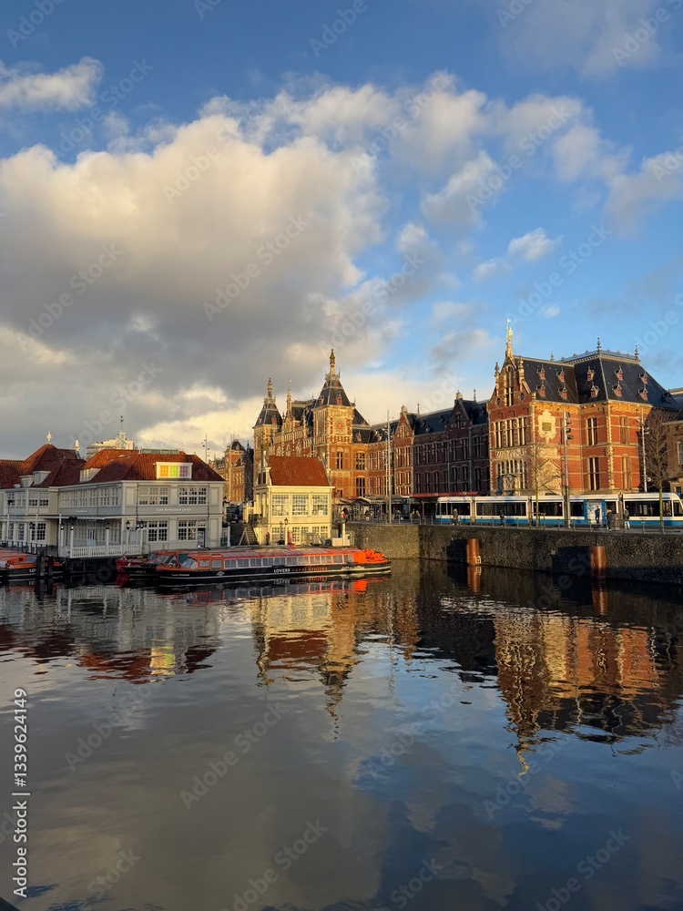 Fototapeta premium A scenic canal in Amsterdam, Netherlands, with historic Dutch buildings lining the waterfront.
