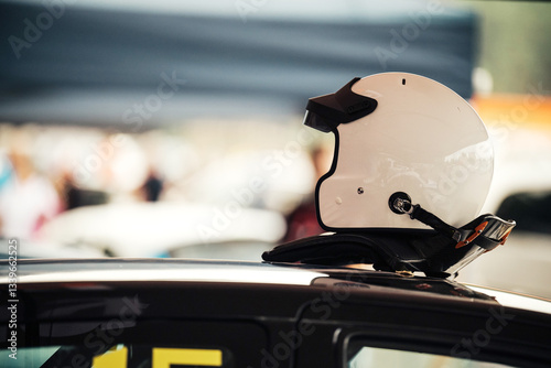 Racing helmet on car roof emphasizing motorsports safety photo
