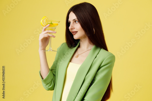 Obraz na płótnie Fashion portrait of beautiful model in green suit with glass of lemonade against yellow background w salonie