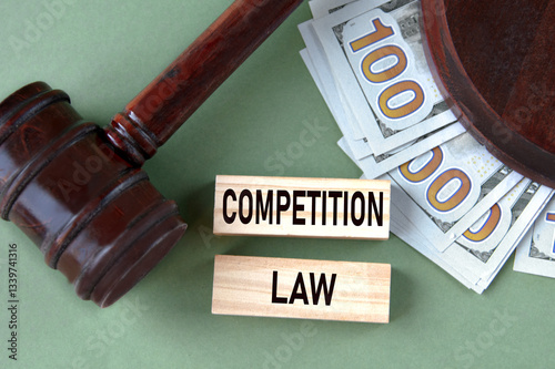 COMPETITION LAW - words on wooden blocks against the background of a judge's gavel and banknotes photo