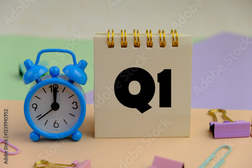 Close up of white notebook with alphabet Q1 on office desk. first quarter concept.