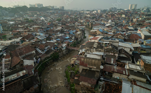 Drone view densely populated residential area with dirty river at Bandung City, 2025. West Java, Indonesia.