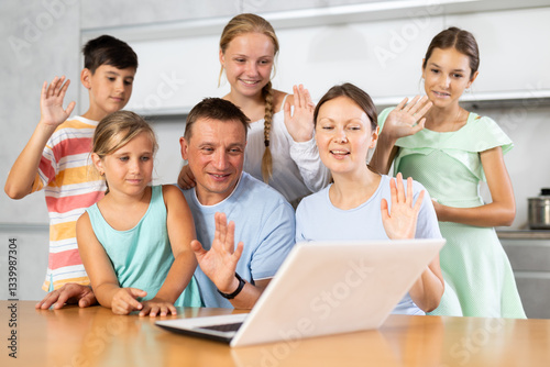 Big family meeting together at home kitchen for making video call