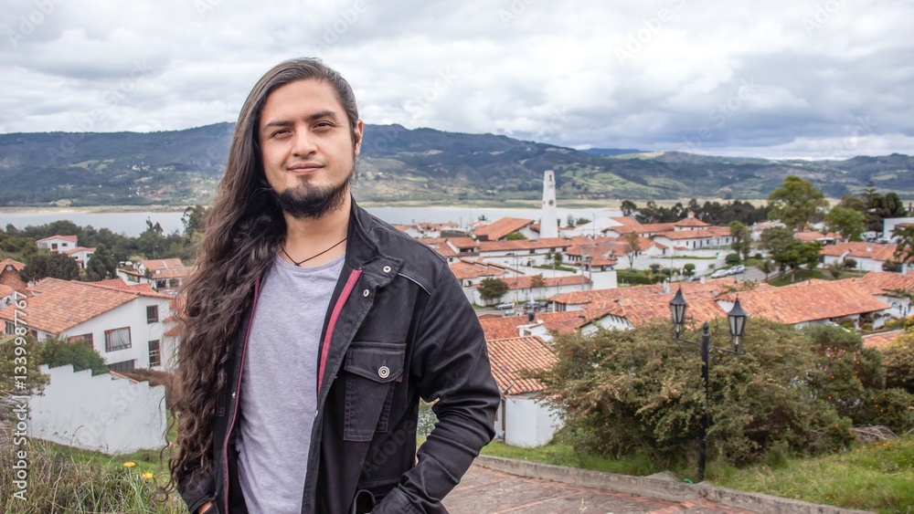 Naklejka premium Traveler - tourist with the landscape of Guatavita, Colombia behind him. View of the lake and the old town of Guatavita in Colombia