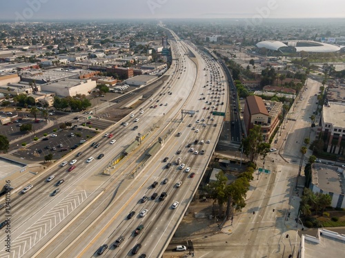 Aerial view of traffic on the 110 freeway in Los Angeles, California, USA. Cars are commuting during the day, with SoFi Stadium visible in the background. photo