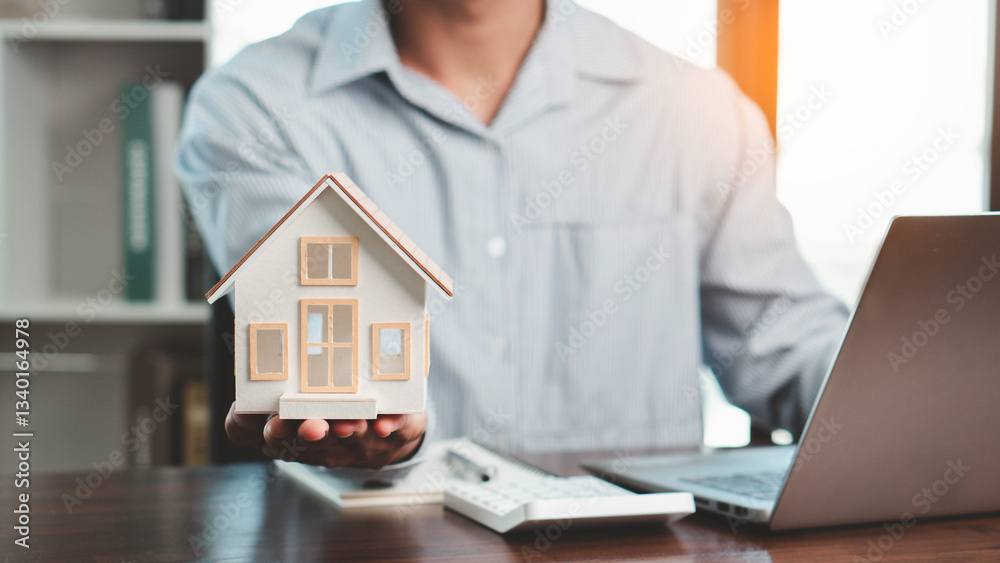 Businessman holding model house showing real estate market growth, real estate and investment concept, real estate market analysis or economic development concept. Businessman holding model house showing real estate market growth, real estate and investment concept, real estate market analysis or economic development concept.