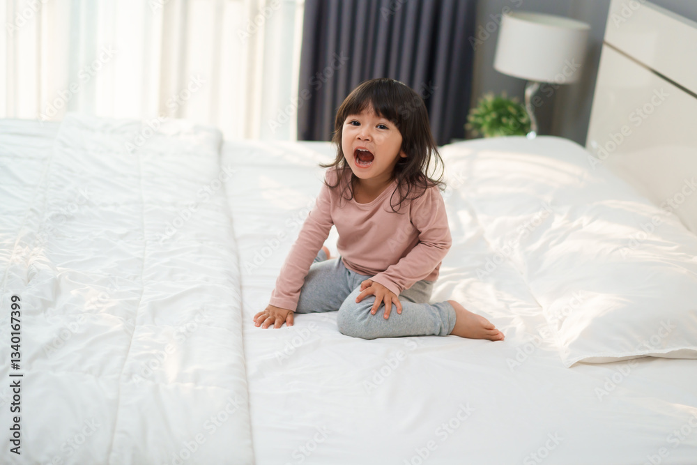 cheerful toddler girl playing and laughing on bed cheerful toddler girl playing and laughing on bed