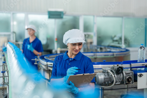 Caucasian female industry worker team working in factory warehouse.