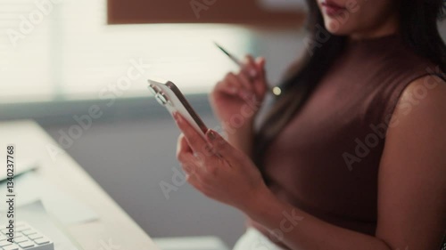 Office worker holding a smartphone and a stylus