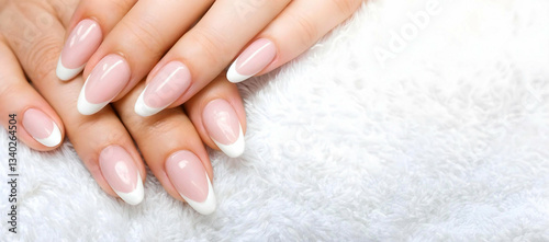Elegant well-groomed female hands on a white background with a subtle floral pattern. Concept femininity and care through the aesthetics of hands.