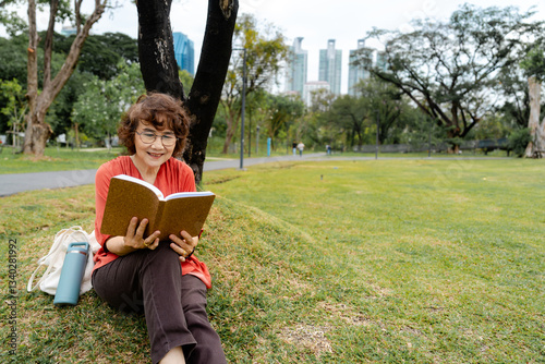Joyful Senior Woman Enjoys Reading Book at Park for Mental Health and Wellbeing in Urban Green Space