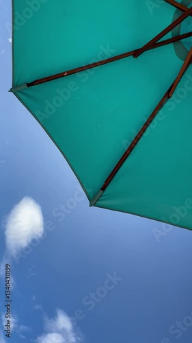 blue beach umbrella view from below against blue sky