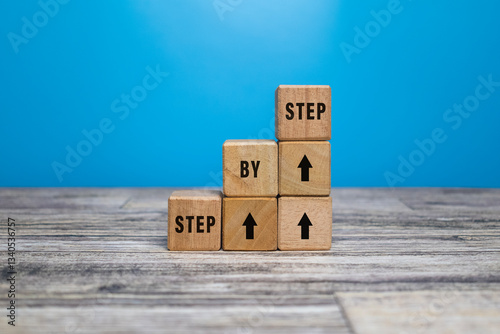 step by step word on wooden blocks staircase isolated on blue background. concept of success progress or career