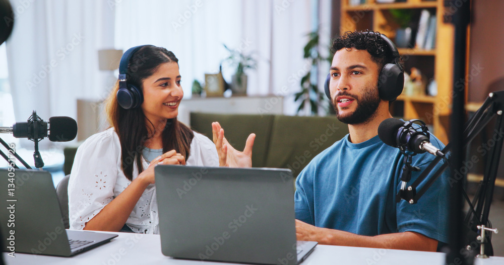 Laptop, podcast and streaming with people in home living room for live broadcast or recording. Computer, conversation or microphone with man and woman influencer in apartment for subscription service Laptop, podcast and streaming with people in home living room for live broadcast or recording. Computer, conversation or microphone with man and woman influencer in apartment for subscription service
