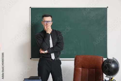 Thoughtful male teacher nea...