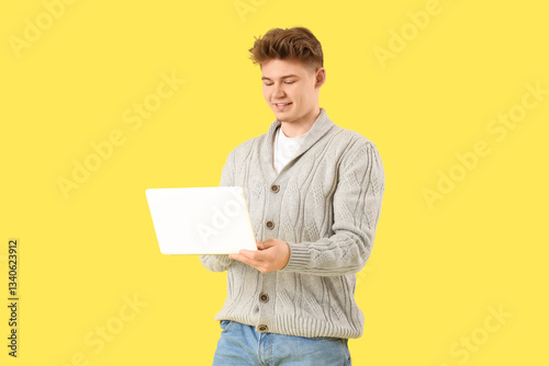 Young man using laptop on y...
