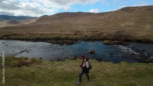 Woman backpacker hiking on trail by the Erriff river near Aesleagh falls, county Mayo, Ireland, aerial, Irish landscape, nature and mountains photo