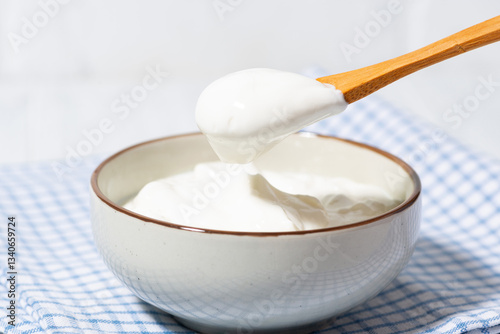 thick greek yogurt in a bowl and a spoon with yogurt
