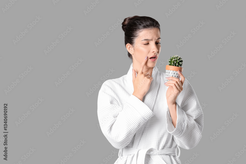 Beautiful young thoughtful woman with cactus on grey background, closeup. Depilation concept Beautiful young thoughtful woman with cactus on grey background, closeup. Depilation concept