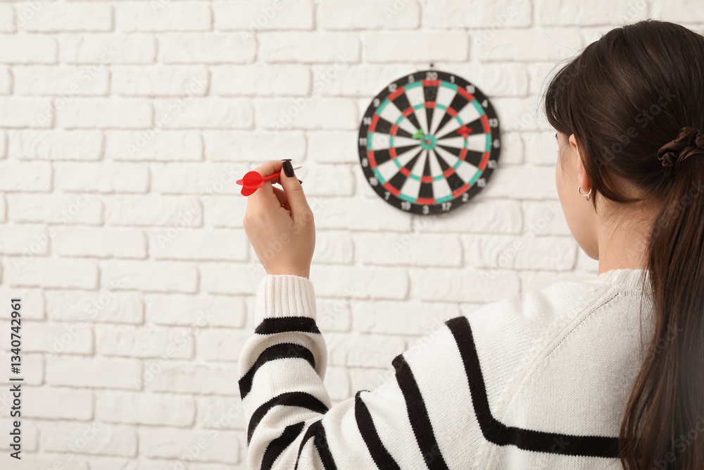 Young woman playing darts indoors Young woman playing darts indoors