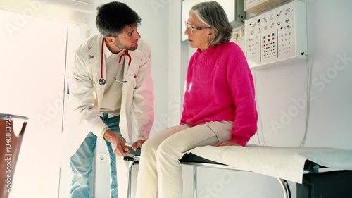 Doctor examining senior woman's knee reflexes in medical office