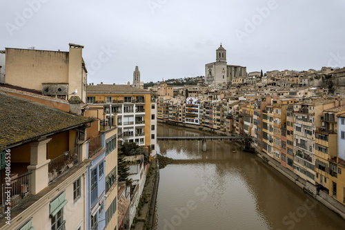 Obraz na płótnie Girona city, view over the Onyar river with the hanging houses over the banks and the Cathedral at the background, during a cold, overcast winter day. w salonie