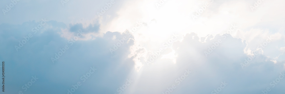 Beautiful sky background with clouds and sunbeams. Dramatic cloudscape with sun rays. Bright sunshine and sunny glow. Wide panoramic background for design.