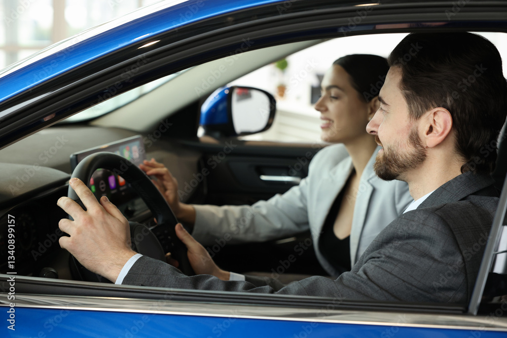 Happy saleswoman and client inside new car in salon, selective focus Happy saleswoman and client inside new car in salon, selective focus