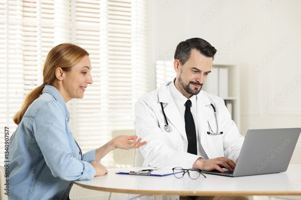 Woman having consultation with cardiologist at desk in clinic Woman having consultation with cardiologist at desk in clinic
