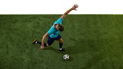 Overhead view of footballer in blue uniform preparing to strike ball, body leaning forward, arms extended for balance on green field. Concept of tactics, technique, teamwork, championship, precision.