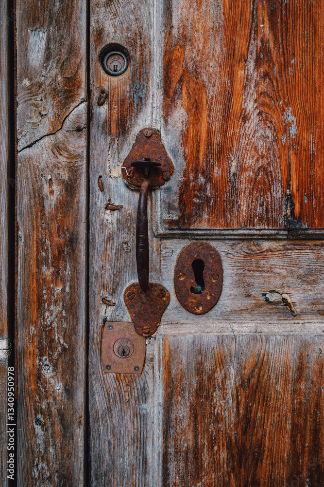A close-up view of an old wooden door with weathered textures and rusty hardware, showcasing timeworn beauty and rustic charm. Ideal for vintage, architectural, and texture-themed projects