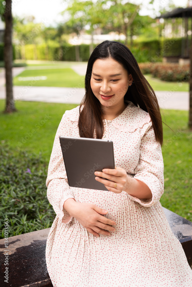 Pregnant woman using digital tablet outdoors Pregnant woman using digital tablet outdoors