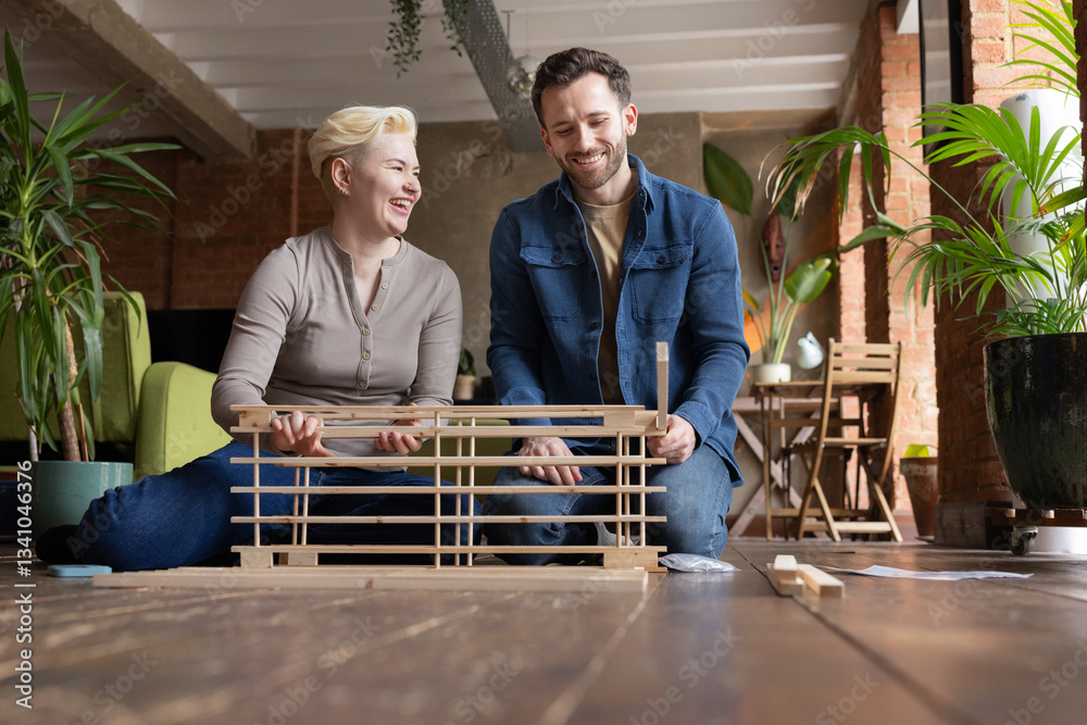 Couple laughing and putting furniture together in their new home