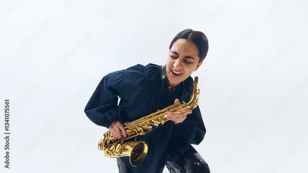 Naklejka premium Woman passionately performing, immersed in music, eyes closed, feeling every note while playing golden saxophone against white studio background. Concept of music, festival, jazz, art, improvisation.