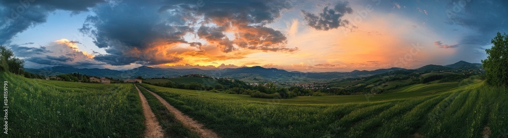 Obraz premium Scenic dirt road at sunset, fields, mountains