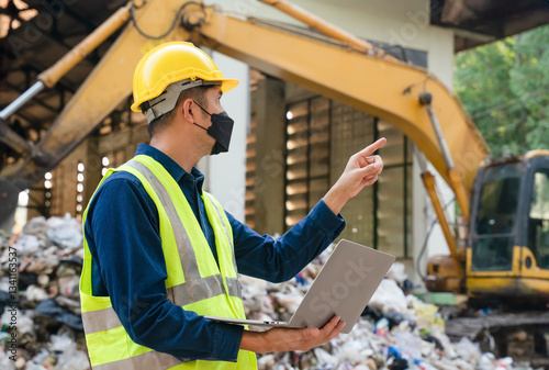A waste management specialist in protective gear oversees a landfill site, ensuring compliance with sustainability and environmental protection standards.