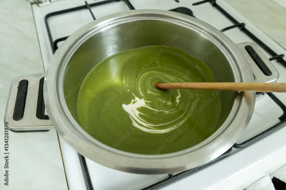 Fototapeta premium Stirring cream into the broccoli cream soup.