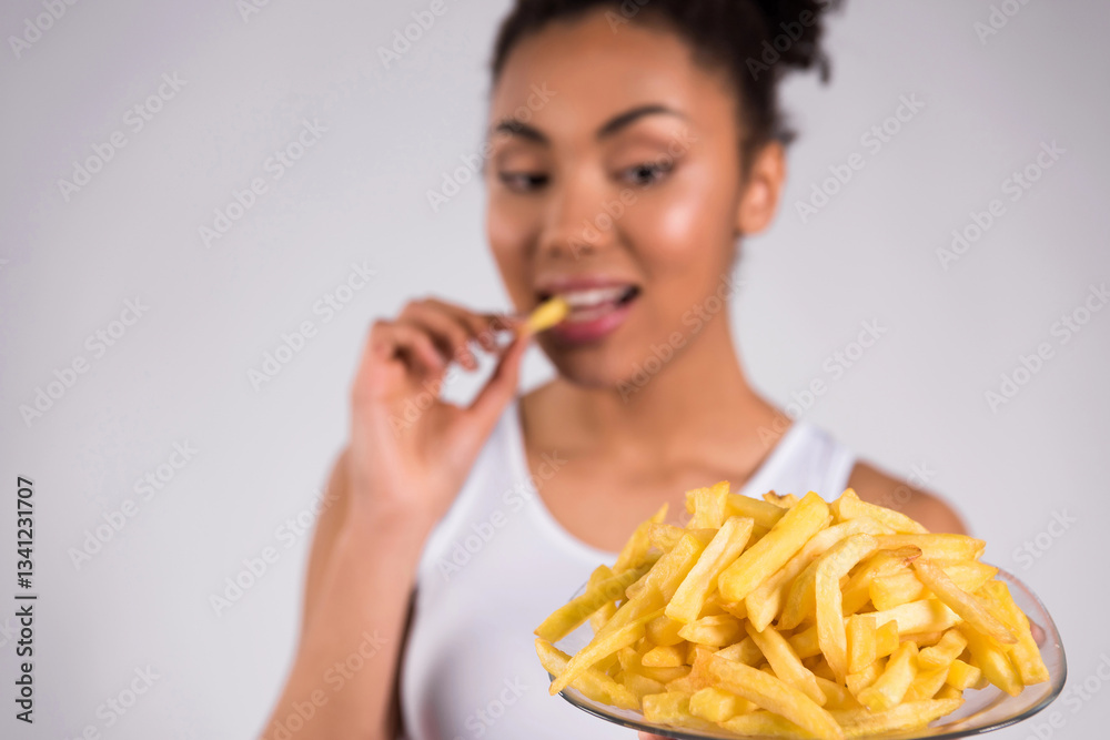 African American girl eating fries isolated. African American girl eating fries isolated.