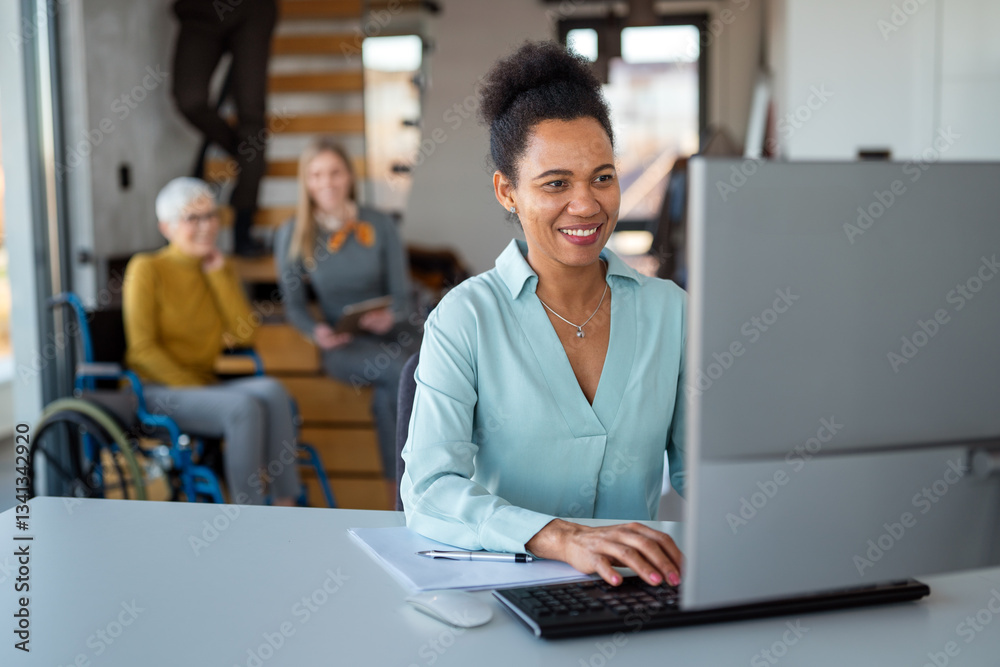 © NDABCREATIVITY - Business woman working on laptop computer reading financial document report in office