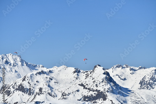 Paragliders over the snowy French alps by winter
