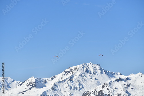 Paragliders over the snowy French alps by winter