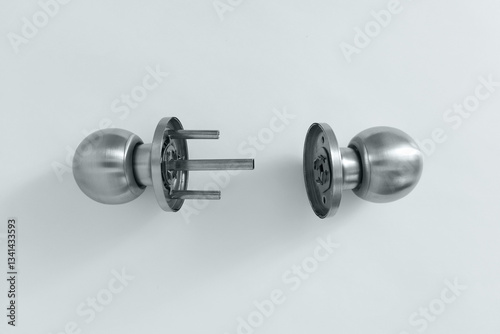 Silver metal disassembled door handle on white background.