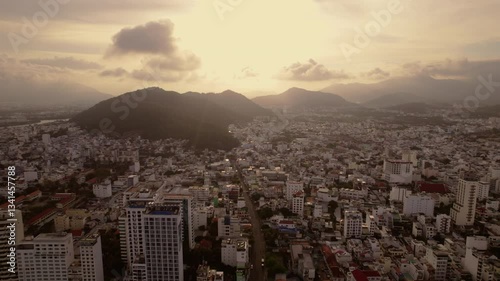 Aerial view of city Nha Trang in Vietnam. Amazing landscape and sunset in turist city in Asia. Popular city in south Asia on ocean shore with blue and ceal ocean.